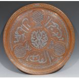 A Middle Eastern silver damascened copper circular tray, inlaid in the Islamic taste with Arabic