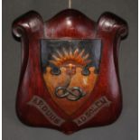 A 19th century oak armorial shield, carved and polychrome painted with the arms and motto of
