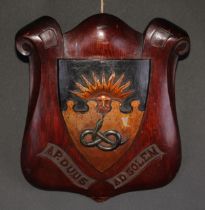 A 19th century oak armorial shield, carved and polychrome painted with the arms and motto of
