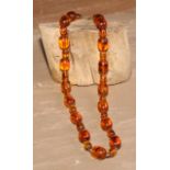An amber coloured bead necklace, 57cm long