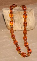 An amber coloured bead necklace, 57cm long