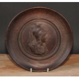 A 19th century Classical Revival oak roundel, centred by a bust-length profile of Athena, ancient