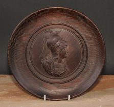 A 19th century Classical Revival oak roundel, centred by a bust-length profile of Athena, ancient