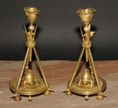 A pair of French gilt bronze candlesticks, cast in the Neo-Classical taste with triumphal regalia,