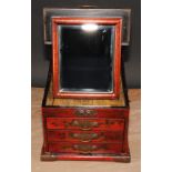 A Chinese red lacquer table top vanity chest, hinged cover enclosing a folding mirror, above three