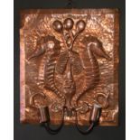 An Arts and Crafts copper wall sconce, repousse chased in the manner of Newlyn with a pair of