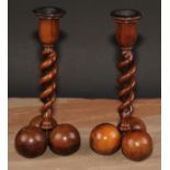 A pair of Middle Eastern olivewood open-twist candlesticks, each triform base composed of three