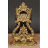 A 19th century brass pocket watch stand, cast throughout with leafy scrolls, shaped oval base, 24.