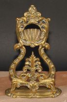 A 19th century brass pocket watch stand, cast throughout with leafy scrolls, shaped oval base, 24.