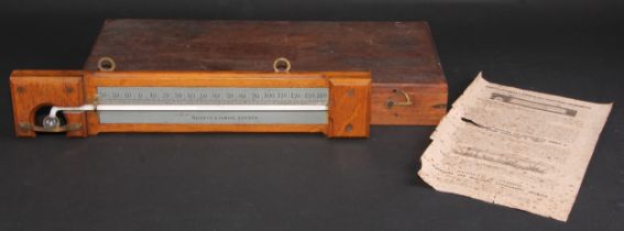 A Negretti & Zambra minimum self-registering thermometer, silvered register, oak mount, 35.5cm long