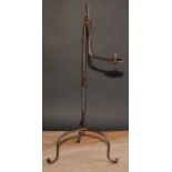 A wrought iron nip rushlight holder, the hinged arm with pricket candlestick, twisted pillar, 56cm