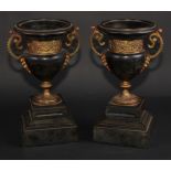 A pair of 19th century gilt metal mounted black marble campana mantel urns, each with turned rim