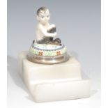 An early 20th century silver mounted desk inkwell, the hinged cover surmounted by a figure of a