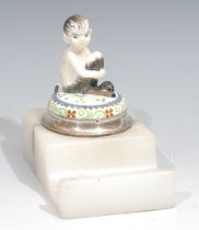 An early 20th century silver mounted desk inkwell, the hinged cover surmounted by a figure of a