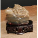 A Chinese hardstone seal, carved with a dragon, 6.5cm wide, hardwood stand