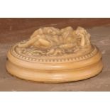 A 19th century lava oval desk weight, in relief with Diana the Huntress sleeping, waisted oval base,