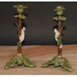 A pair of Austrian cold painted bronze novelty candlesticks, each cast with a squirrel climbing