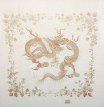 A Chinese needlework picture, worked in two-tone threads with a ferocious dragon, within a flowering