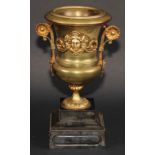 A Neo-Classical Revival brass campana mantel urn, applied with a cast mask, scroll handles