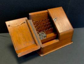 A twentieth century oak stationary box, hinged doors, fitted interior, lock and key, 30cm high x