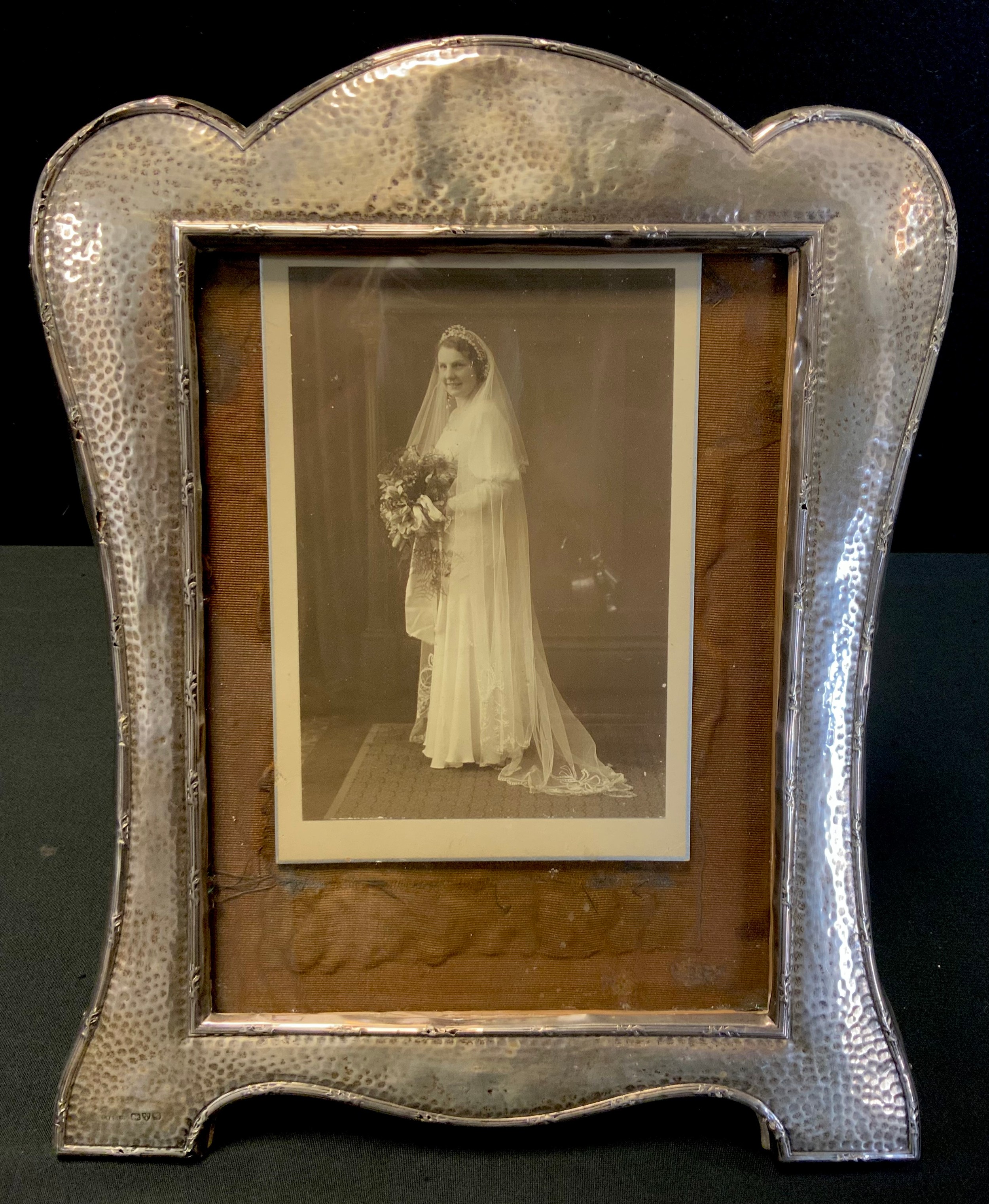 An Edwardian Arts and Crafts silver photograph frame, arched top, easel stand, S Blanckensee & Son