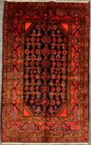 A North west Persian Hamadan rug / carpet, hand-knotted in deep tones of red, brown, and blue, on