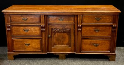 A 20th century crossbanded oak low dresser, with an arrangement of seven drawers flanking central