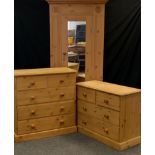 A pine three piece bedroom suite, comprising single door wardrobe, with carved roundel detailed