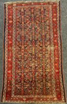 A Persian Farahan rug, hand-knotted with asymmetrically patterned field, in tones of red, white,