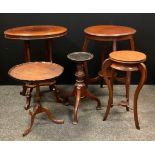 An Edwardian mahogany oval occasional table, four tapering columns, inverted undertier, shaped