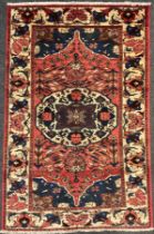 A central Persian Bakhtiar rug / carpet, hand-knotted in muted tones of red, blue, and cream,