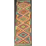 A Turkish Anatolian Kilim runner carpet, knotted with a central row of five diamond-shaped