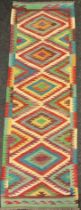 A Turkish Anatolian Kilim runner carpet, knotted with a central row of five diamond-shaped