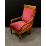 A Victorian mahogany nursing chair, scrolling arms, upholstered back and seat, turned fore legs,