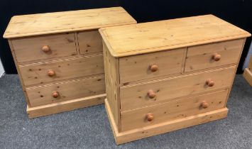 A pair of pine four drawer chests, each with rounded oversailing tops, two short over three long
