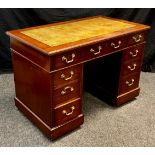 A early 20th century mahogany pedestal table; faux leather top, three drawers to frieze, three