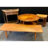 A mid 20th century teak Nathan Cog circular coffee table, geared wheel quartered top, shelf