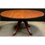 A large 20th century mahogany centre table, reeded rim, four sabre leg pedestal base, scroll