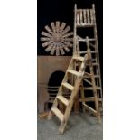 A pair of wooden six step folding ladders; another smaller; cast iron fire back; wooden and metal