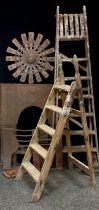 A pair of wooden six step folding ladders; another smaller; cast iron fire back; wooden and metal