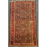 A Persian Farahan rug, hand-knotted with asymmetrically patterned field, in tones of red, white,