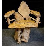 A tree root, naturalistic garden chair, the base of interlocking teak tree roots, with a seat of