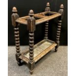 An early 20th century carved oak umbrella /stick stand, two section top, turned columns