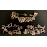 A silver and white metal charm bracelet, suspending twenty six charms, two other bracelets
