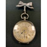 A continental 935 silver open face pocket watch, floral case, suspended from a sterling tied