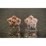 A pair of diamond cluster earrings, each set with six round brilliant cut diamonds, total