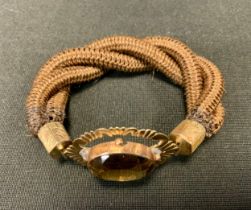 A 19th century hair work bracelet, triple strand links, yellow metal clasp with a central deep