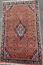 A Middle Eastern ‘Isfahan’ style silk and wool mix rug, hand-knotted in tones of red, deep and