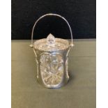 A George V silver and glass preserve jar and cover, pierced drum shaped basket, swing handle,