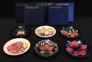 Moorcroft Pottery - six circular dishes, each in a different pattern including Frangipani, Oberon,